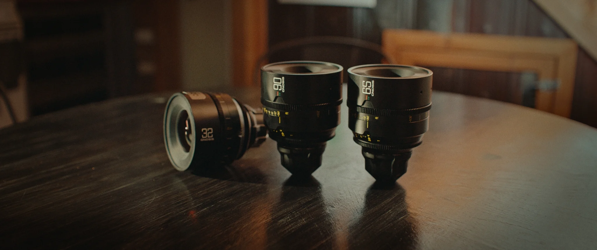 photo of three camera lenses on a wooden table