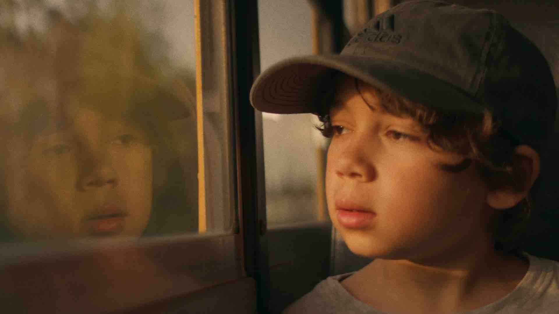 young child looking out bus window